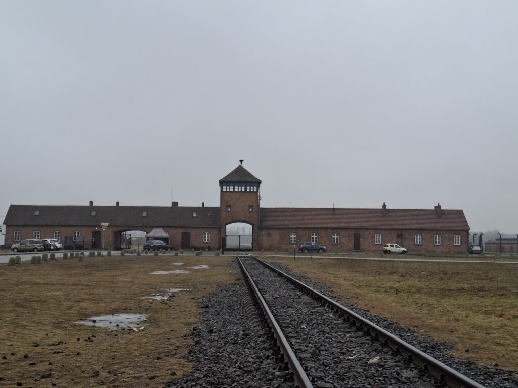 Das Bild zeigt das Haupttor eines historischen Backsteingebäudes an einem grauen Tag