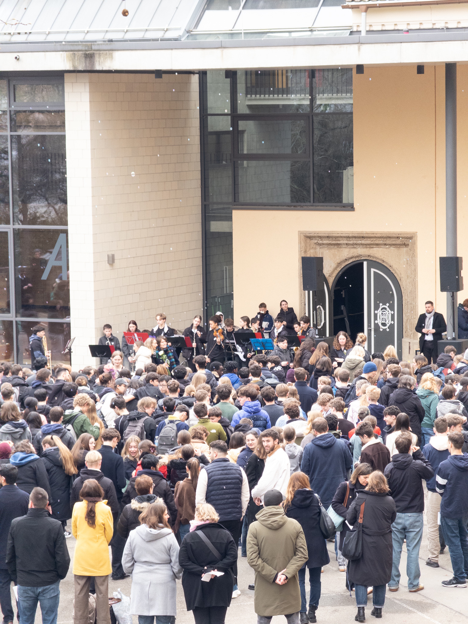 Eine große Menschenmenge steht vor einem Gebäude, viele wirken gespannt und interessiert