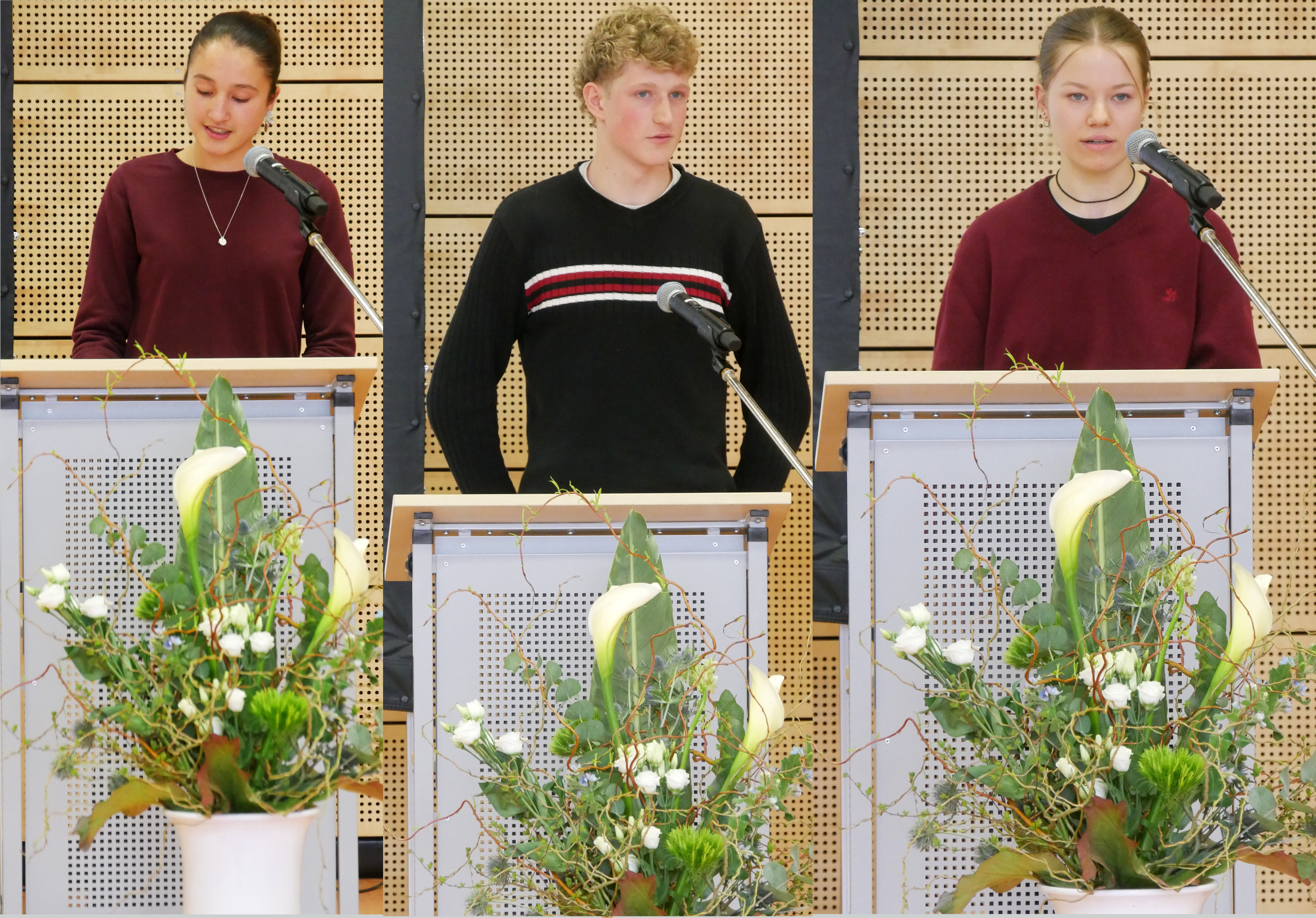 Drei Personen neutral an Rednerpulten in Rot Schwarz mit Blumen vorne