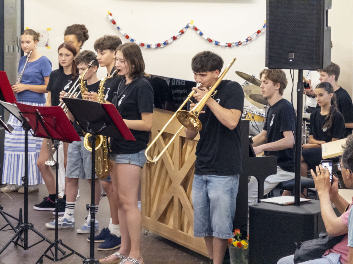 Jugendliche mit konzentriertem Ausdruck spielen Blasinstrumente in Schwarz und Blau