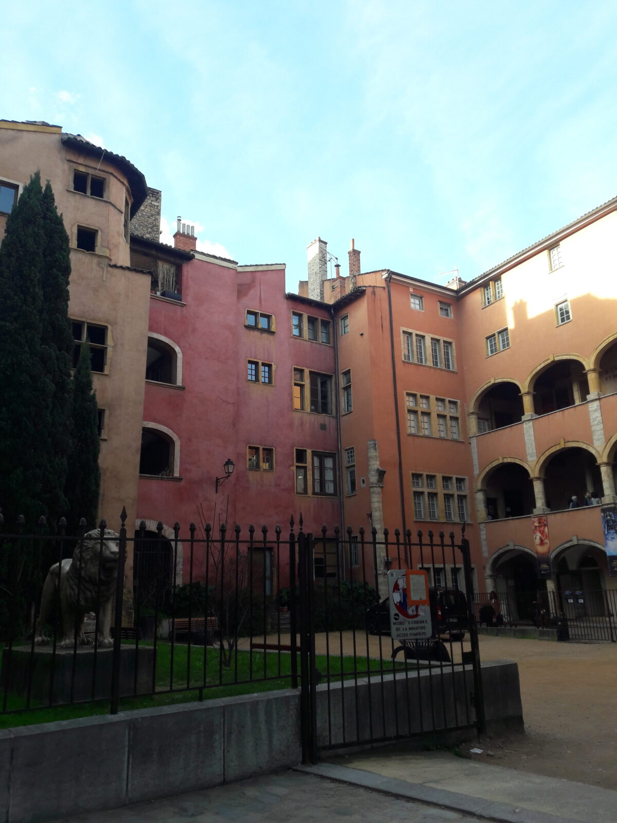 Ruhiger Innenhof mit farbigen Fassaden in Rosa und Ocker und Arkaden