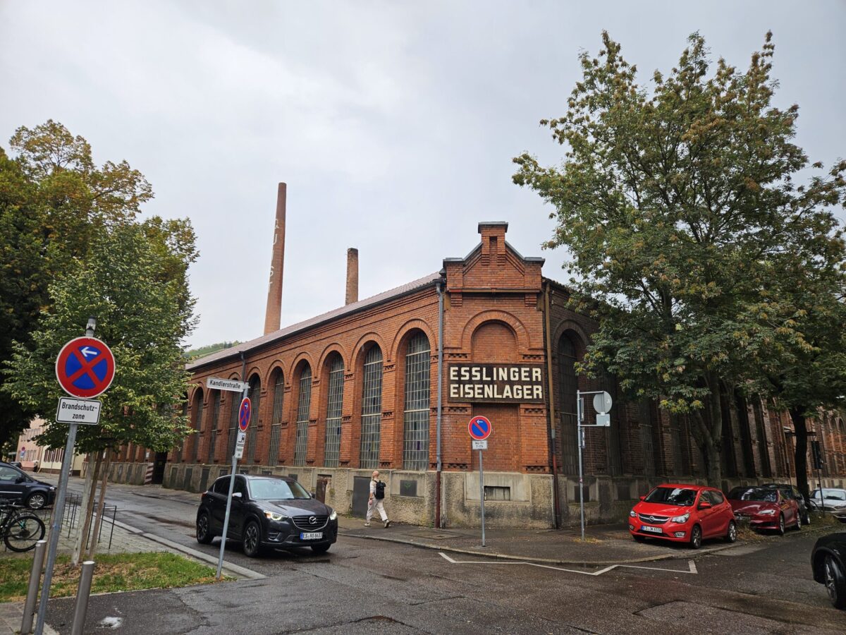 Historisches rotes Backsteingebaeude Esslinger Eisenlager mit Autos davor