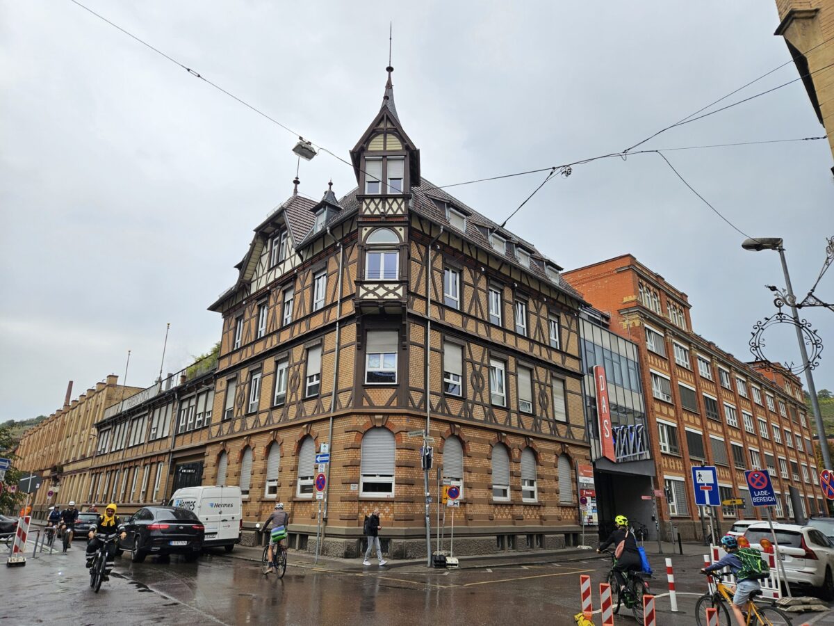 Historisches Fachwerkgebaeude mit Turm an einer Strassenecke mit Radfahrern